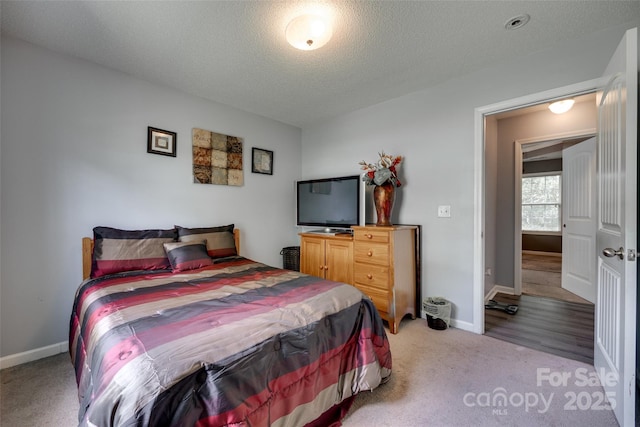 bedroom featuring baseboards, carpet flooring, and a textured ceiling