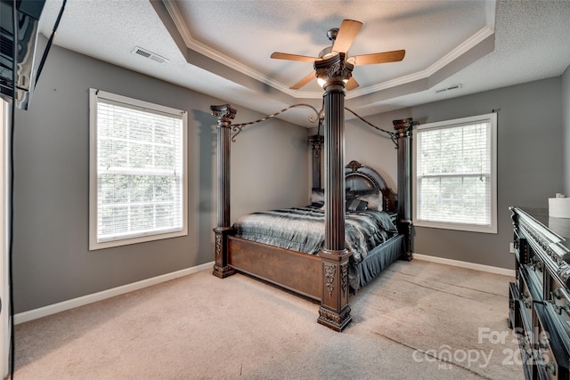 bedroom featuring a tray ceiling, crown molding, and a textured ceiling