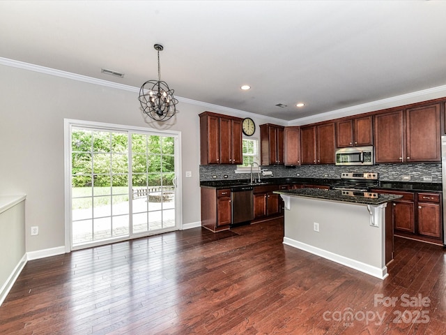 2369 Baxter Pl SE, Concord, NC 28025 - kitchen with tasteful backsplash, a chandelier, appliances with stainless steel finishes, visible vents, and crown molding