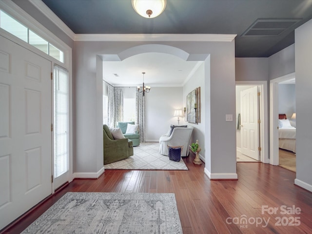 entryway featuring crown molding, visible vents, plenty of natural light, and wood-type flooring