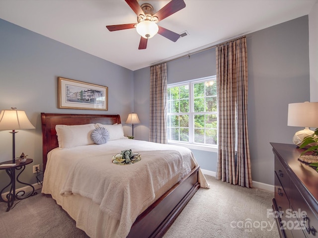 bedroom featuring light colored carpet, baseboards, ceiling fan, and visible vents