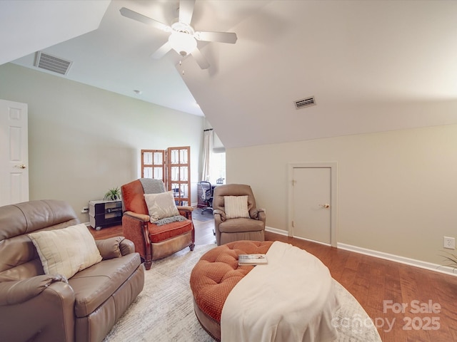 living area with a ceiling fan, vaulted ceiling, light wood finished floors, and visible vents
