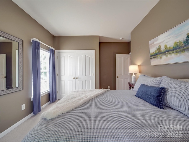bedroom with a closet, carpet, and baseboards