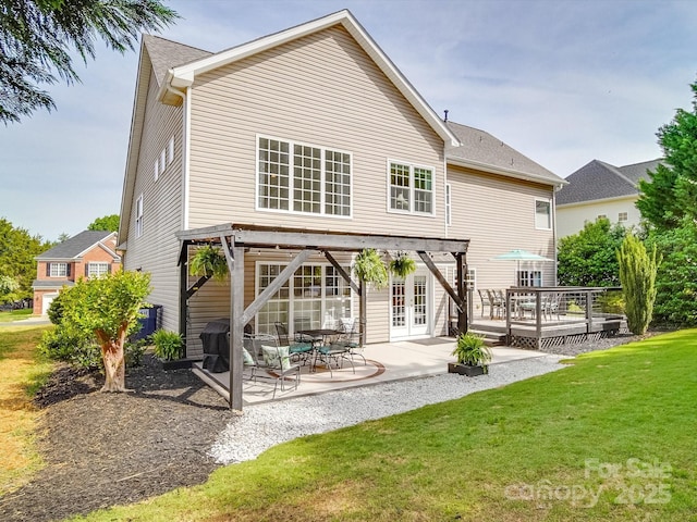 back of house featuring french doors, a patio, a lawn, and a deck