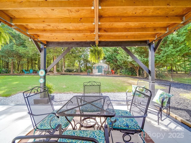 view of patio / terrace featuring outdoor dining area, an outdoor structure, and fence
