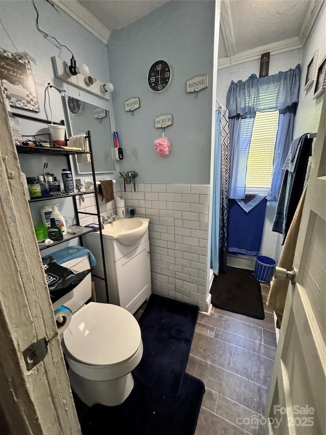 336 Hamilton Dr NE, Concord, NC 28025 - bathroom featuring vanity, ornamental molding, toilet, tile walls, and a wainscoted wall
