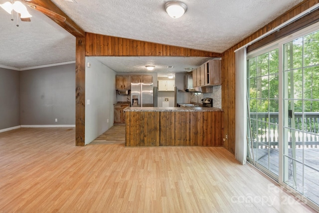 351 Fletcher Rd, Union Grove, NC 28689 - kitchen with a textured ceiling, brown cabinets, a peninsula, light wood finished floors, and stainless steel fridge