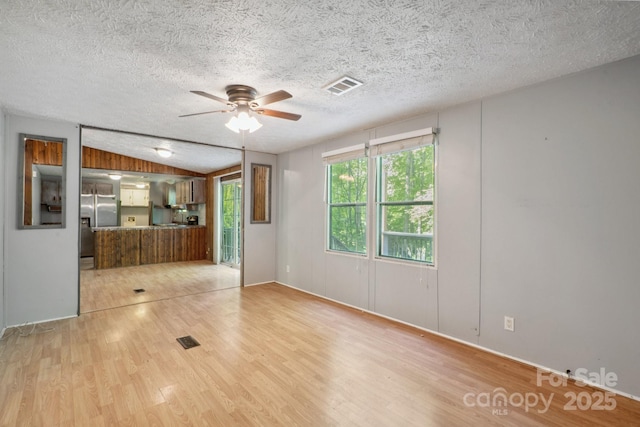 351 Fletcher Rd, Union Grove, NC 28689 - unfurnished living room featuring ceiling fan, visible vents, a healthy amount of sunlight, and light wood-type flooring