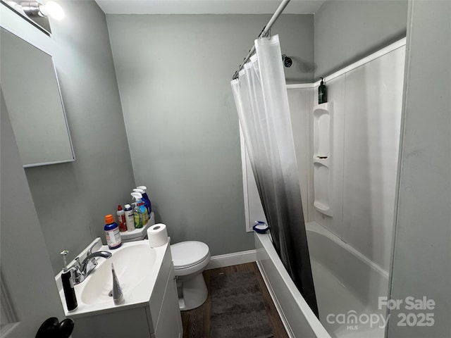 81 Academy Ave NW, Concord, NC 28025 - bathroom featuring vanity, toilet, wood finished floors, shower / bath combo with shower curtain, and baseboards