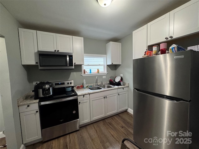 81 Academy Ave NW, Concord, NC 28025 - kitchen featuring appliances with stainless steel finishes, a sink, dark wood finished floors, white cabinets, and light countertops
