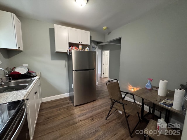 81 Academy Ave NW, Concord, NC 28025 - kitchen with freestanding refrigerator, a sink, dark wood-style floors, white cabinets, and baseboards