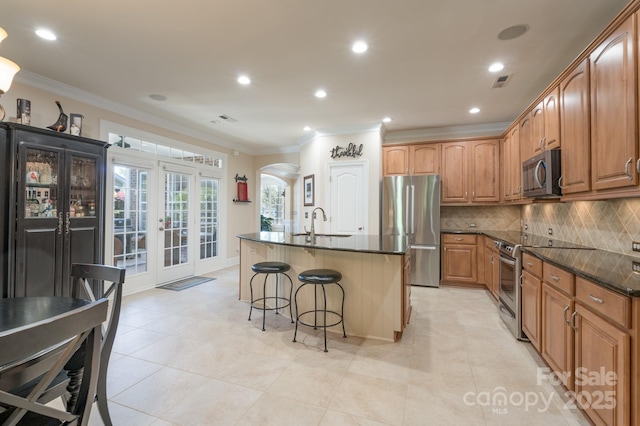 11008 Round Rock Rd, Charlotte, NC 28277 - kitchen featuring visible vents, a kitchen bar, french doors, arched walkways, and appliances with stainless steel finishes