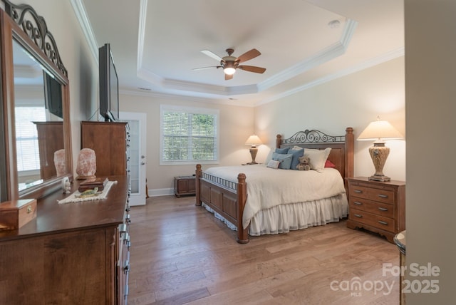 11008 Round Rock Rd, Charlotte, NC 28277 - bedroom featuring crown molding, a ceiling fan, a tray ceiling, and light wood-type flooring