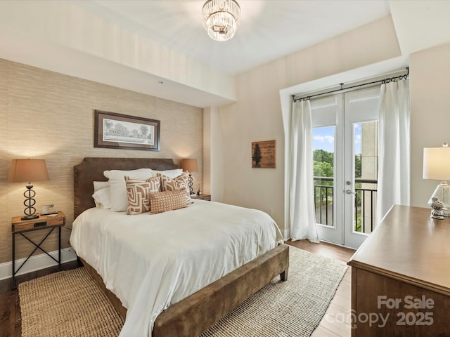 bedroom with access to outside, baseboards, wood finished floors, and french doors