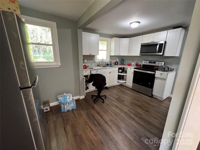 1010 Tennessee St, Kannapolis, NC 28083 - kitchen with appliances with stainless steel finishes, dark wood-type flooring, light countertops, white cabinetry, and baseboards