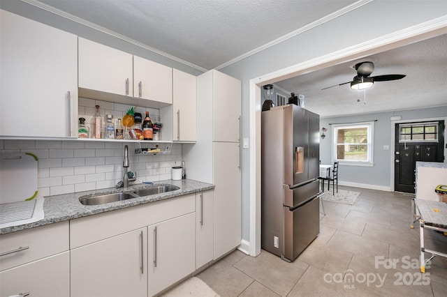 kitchen with tasteful backsplash, a textured ceiling, stainless steel fridge with ice dispenser, and a sink