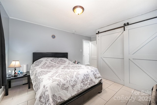 bedroom with ornamental molding, light tile patterned floors, and a barn door