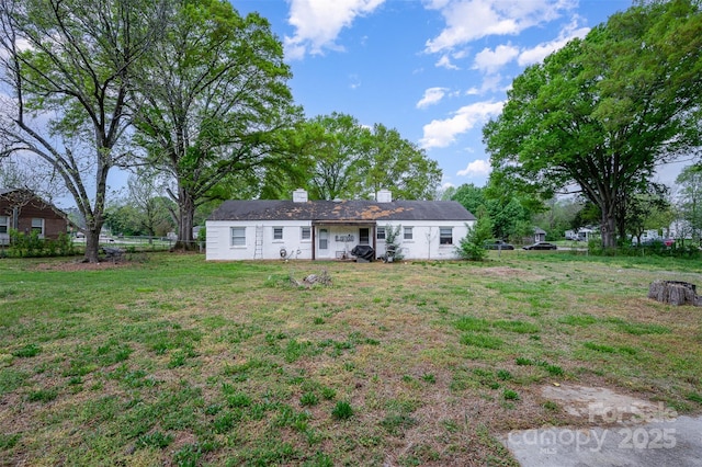 rear view of property with a lawn, fence, and a chimney