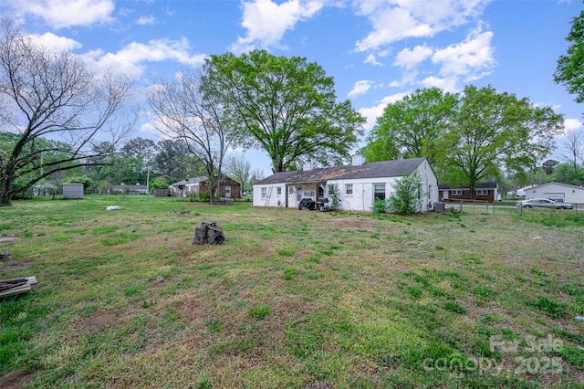 view of yard featuring fence and an outbuilding