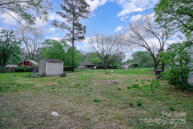 view of yard with an outbuilding, a shed, and fence