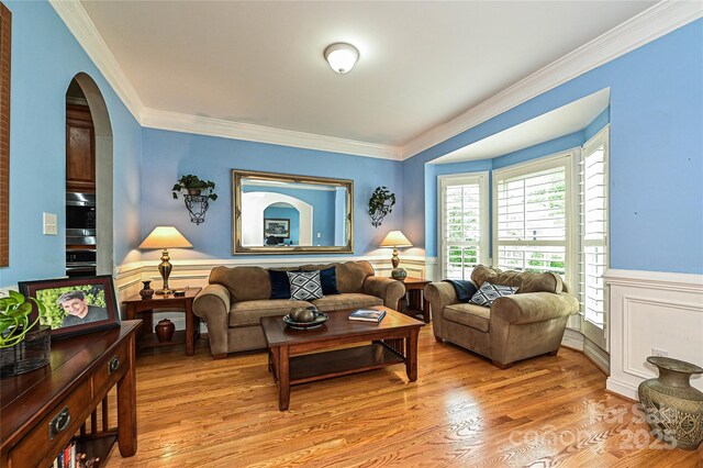 11232 Tradition View Dr, Charlotte, NC 28269 - living area featuring crown molding, a wainscoted wall, light wood finished floors, and arched walkways