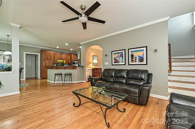 11232 Tradition View Dr, Charlotte, NC 28269 - living room featuring a ceiling fan, ornamental molding, arched walkways, light wood-type flooring, and baseboards