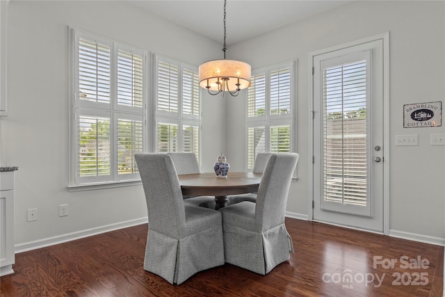 dining area with baseboards, a wealth of natural light, dark wood-type flooring, and a chandelier