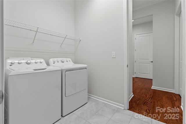 clothes washing area with baseboards, laundry area, and washer and dryer