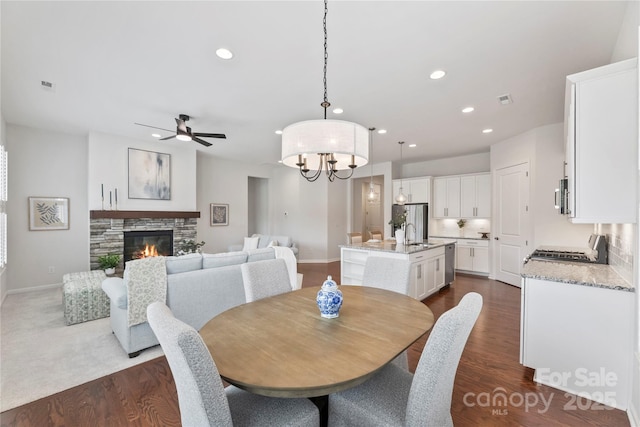 329 Brambling Ct, Wesley Chapel, NC 28110 - dining space featuring recessed lighting, baseboards, ceiling fan, a fireplace, and a chandelier
