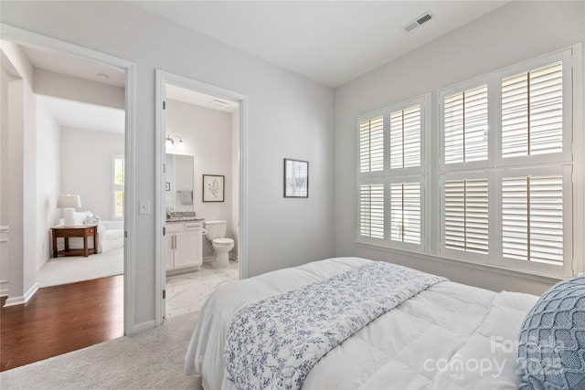 329 Brambling Ct, Wesley Chapel, NC 28110 - carpeted bedroom featuring multiple windows, baseboards, and connected bathroom