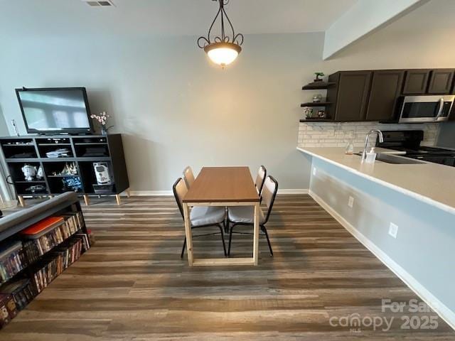 dining space with visible vents, dark wood-style flooring, and baseboards
