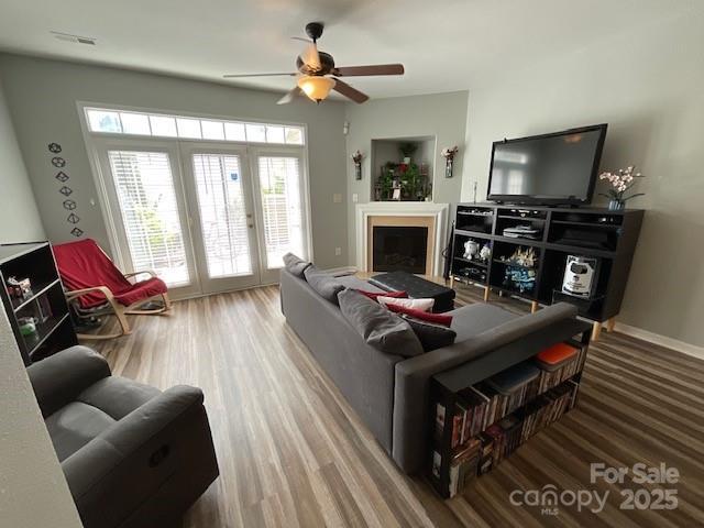 living area featuring a ceiling fan, french doors, wood finished floors, and visible vents