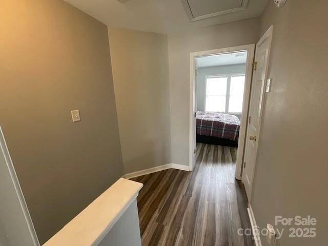hallway with dark wood-style flooring and baseboards