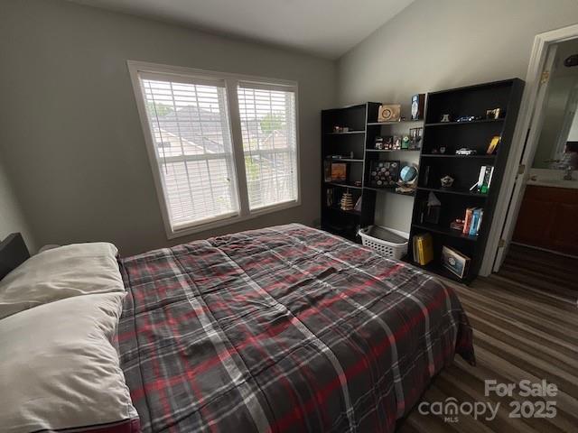 bedroom with connected bathroom and lofted ceiling