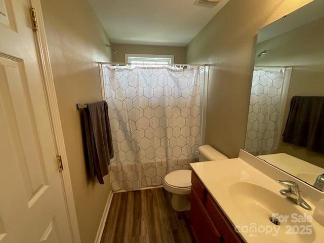 full bathroom featuring shower / bath combo with shower curtain, wood finished floors, toilet, and vanity