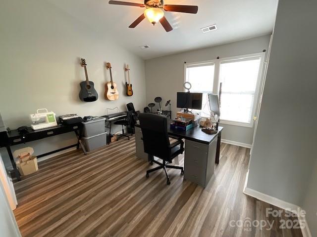 office space with baseboards, visible vents, wood finished floors, and a ceiling fan