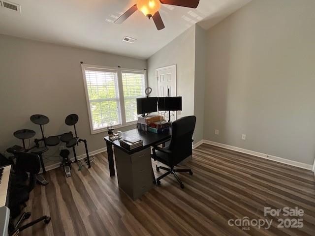 office with visible vents, ceiling fan, dark wood-style flooring, and vaulted ceiling