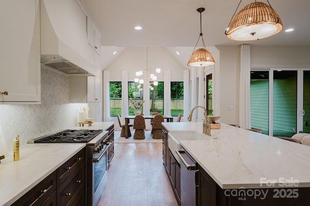 1807 Arnold Dr, Charlotte, NC 28205 - kitchen featuring stainless steel appliances, custom exhaust hood, a sink, light stone countertops, and light wood-style floors