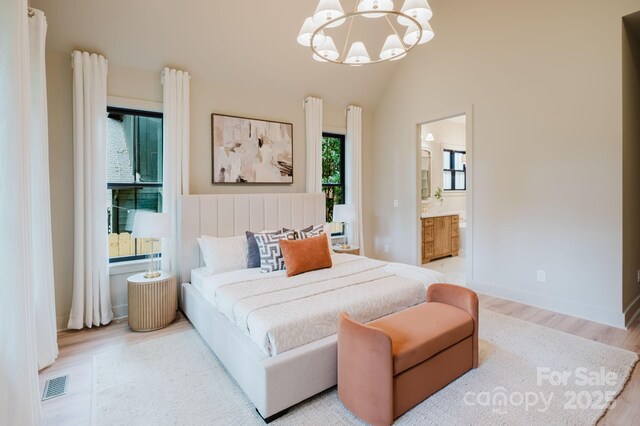 1807 Arnold Dr, Charlotte, NC 28205 - bedroom with a chandelier, wood finished floors, connected bathroom, and lofted ceiling