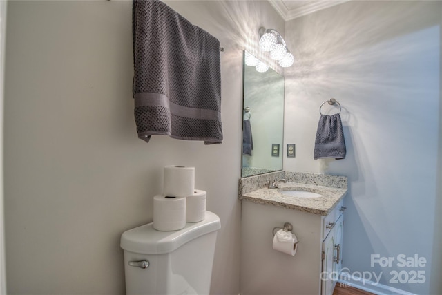 half bathroom with toilet, vanity, and crown molding