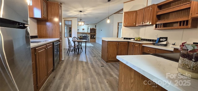 kitchen with wood finished floors, open shelves, appliances with stainless steel finishes, light countertops, and a fireplace