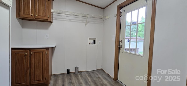 laundry area featuring crown molding, cabinet space, washer hookup, and wood finished floors