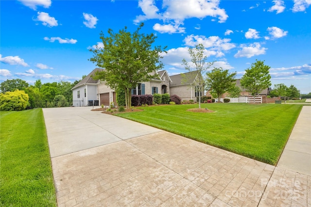 view of front of property featuring concrete driveway, a front yard, a garage, and fence