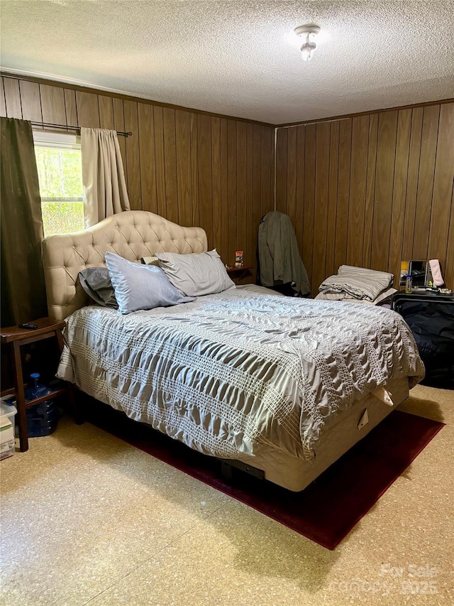 carpeted bedroom featuring wood walls and a textured ceiling