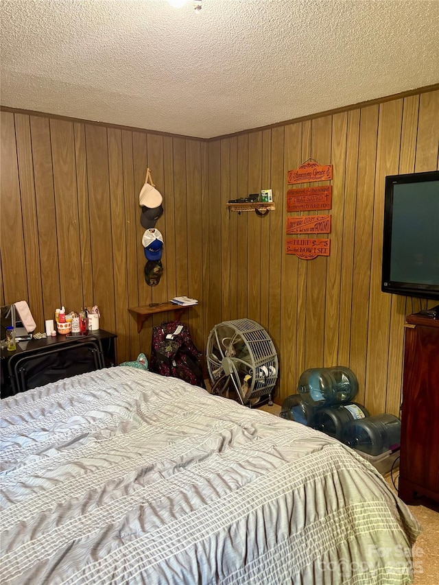 bedroom with wooden walls, a textured ceiling, and carpet