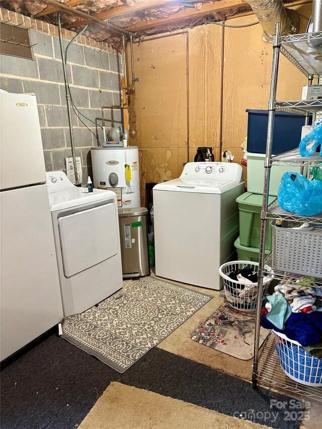 washroom featuring concrete block wall, separate washer and dryer, laundry area, water heater, and electric water heater