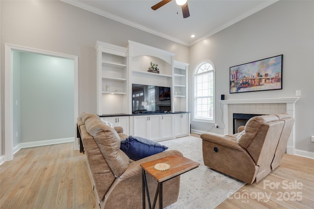 living room featuring baseboards, a ceiling fan, light wood-style flooring, and ornamental molding