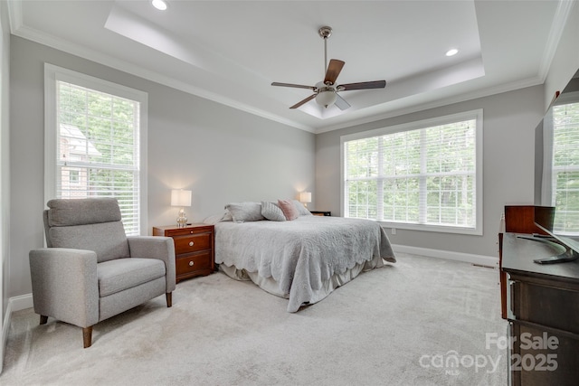 bedroom featuring a tray ceiling, light carpet, and baseboards