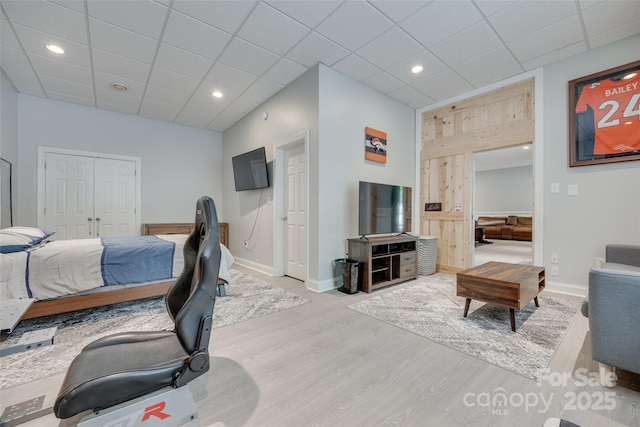 bedroom featuring baseboards, recessed lighting, wood finished floors, and a closet