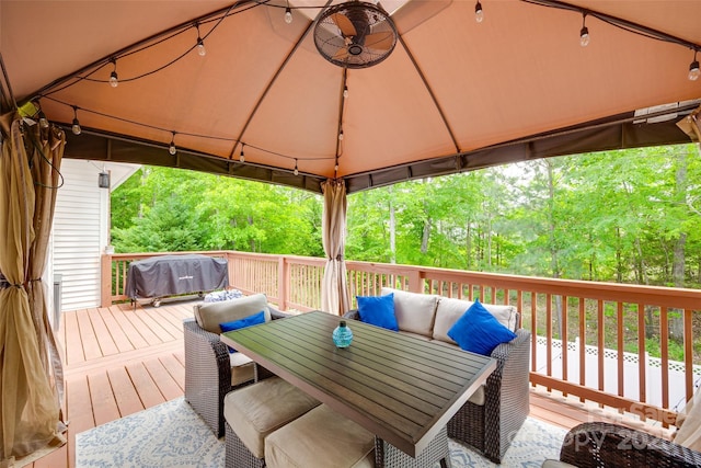 wooden terrace with an outdoor hangout area, outdoor dining space, a gazebo, and grilling area
